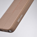 Close-up of a BELVÍN phone case in a warm taupe-brown color, featuring a textured chevron pattern and a white debossed brand logo on the side, set against a clean light gray background.